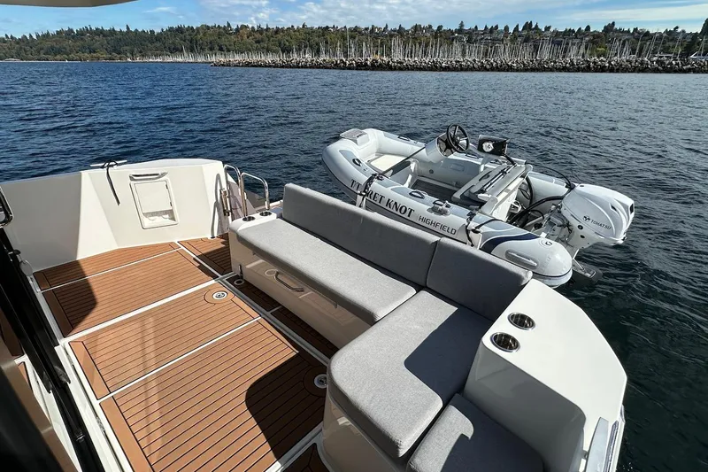 Slide: The Image of 2024 Beneteau Swift Trawler 41 Sedan with spacious deck and tender boat on water. - 17