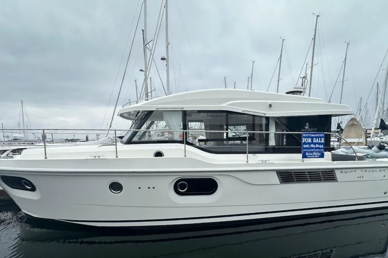 Slide: The Image of 2024 Beneteau Swift Trawler 41 Sedan for sale at marina, side view. - 2