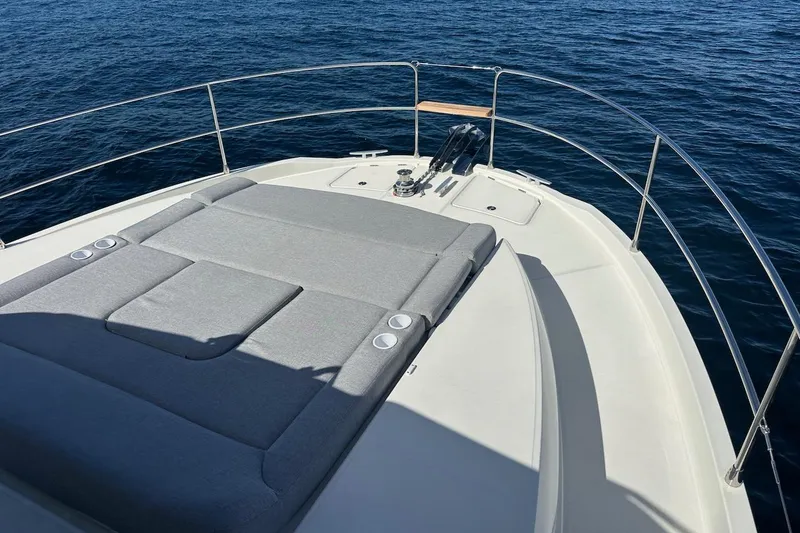 Slide: The Image of 2024 Beneteau Swift Trawler 41 Sedan bow with sunpad, surrounded by ocean. - 23