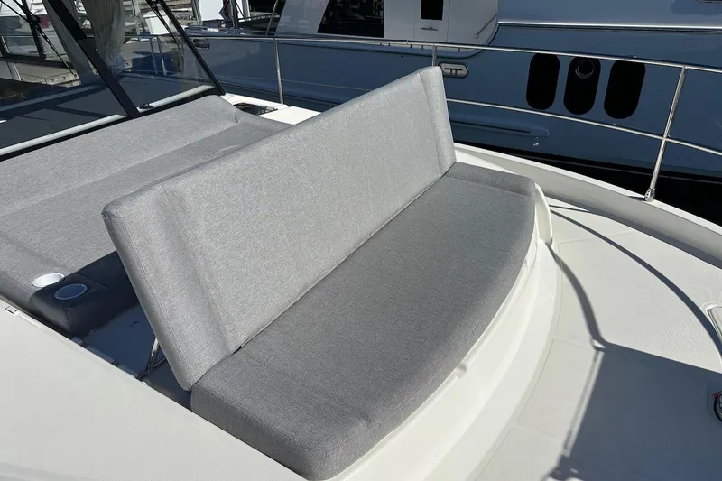 Slide: The Image of 2024 Beneteau Swift Trawler 41 Sedan with gray cushioned seating on deck. - 25