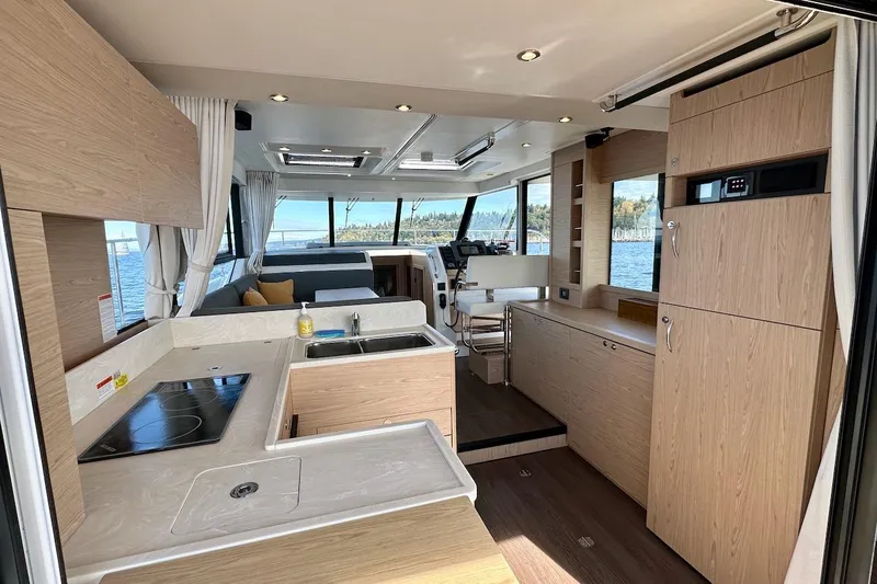 Slide: The Image of 2024 Beneteau Swift Trawler 41 Sedan interior with modern kitchen and panoramic windows. - 33