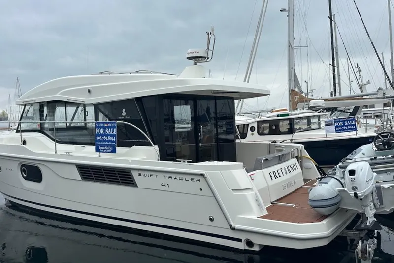 Slide: The Image of 2024 Beneteau Swift Trawler 41 Sedan for sale at marina, side view. - 5
