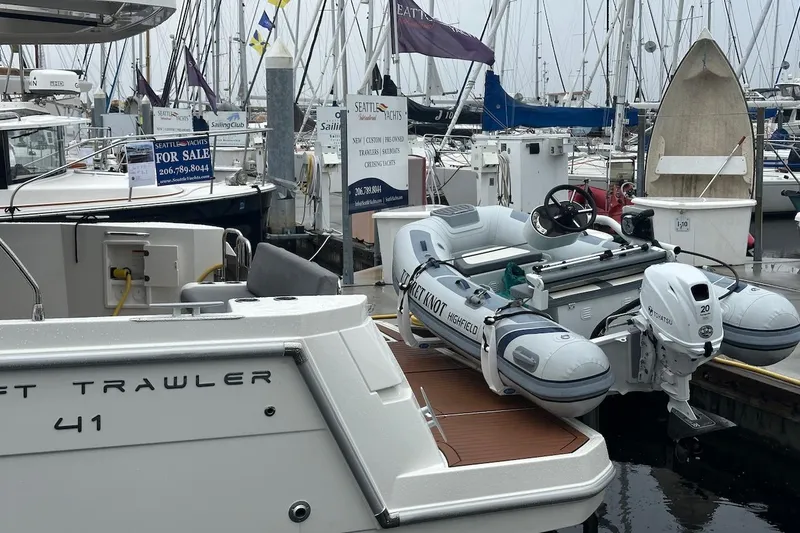 Slide: The Image of 2024 Beneteau Swift Trawler 41 Sedan docked with inflatable boat at marina. - 6
