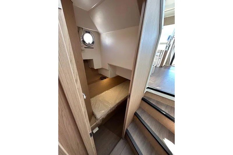 Slide: The Image of Interior view of 2024 Beneteau Swift Trawler 41 Sedan, featuring wooden stairs and compact cabin. - 69