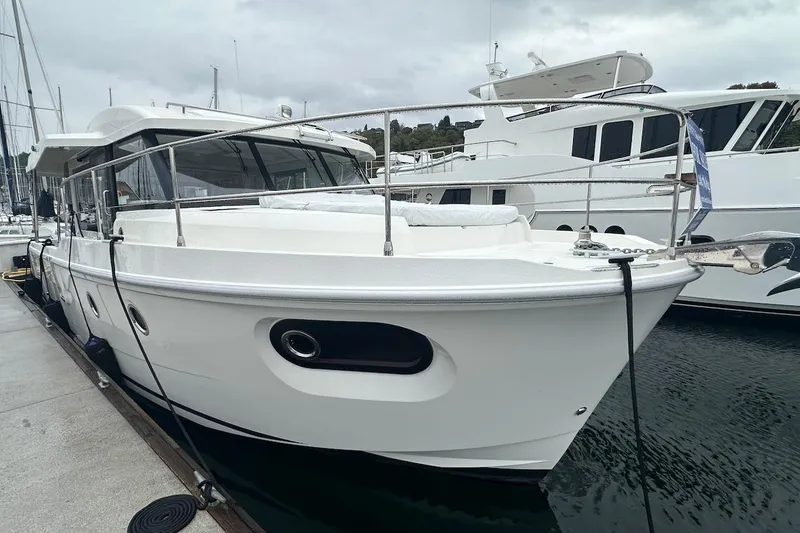 Slide: The Image of 2024 Beneteau Swift Trawler 41 Sedan docked at marina, side view. - 8