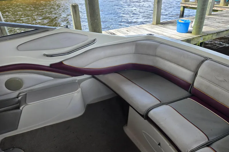 Slide: The Image of 1995 Maxum 2300 SC boat interior with cushioned seating by the dock. - 13