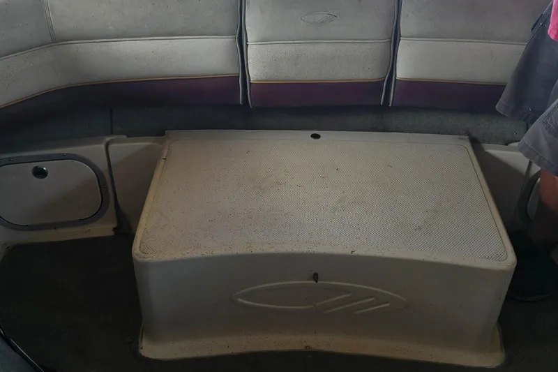 Slide: The Image of Interior seating of a 1995 Maxum 2300 SC boat, featuring cushioned bench and storage area. - 22