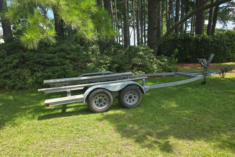Slide: The Image of Boat trailer for 1995 Maxum 2300 SC on grass, surrounded by trees. - 27
