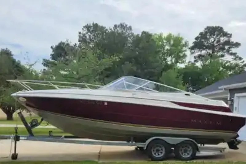 Slide: The Image of 1995 Maxum 2300 SC boat on trailer, parked outdoors with trees in background. - 3