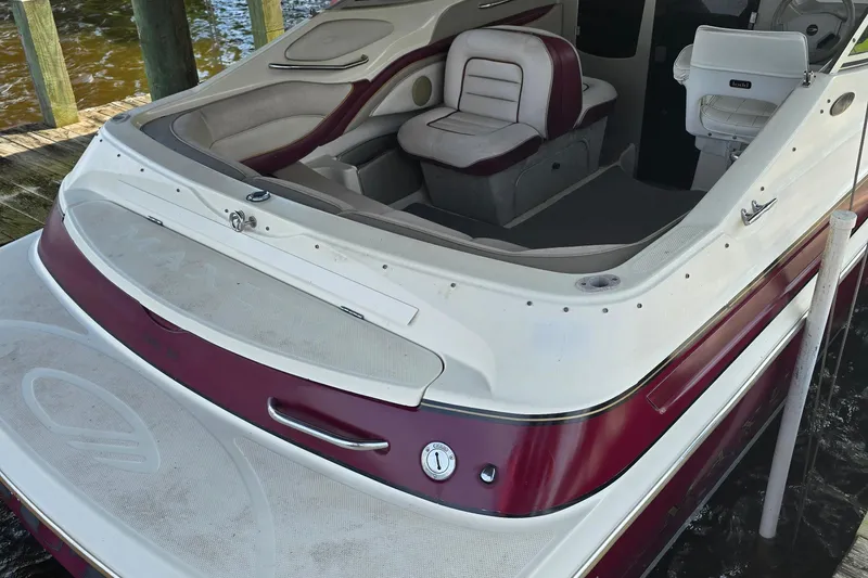 Slide: The Image of 1995 Maxum 2300 SC boat interior with red and white seating, docked by wooden posts. - 5