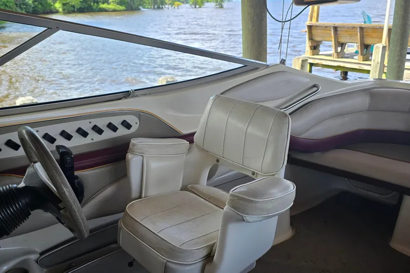 Slide: The Image of Interior of a 1995 Maxum 2300 SC boat with steering wheel and seating. - 8