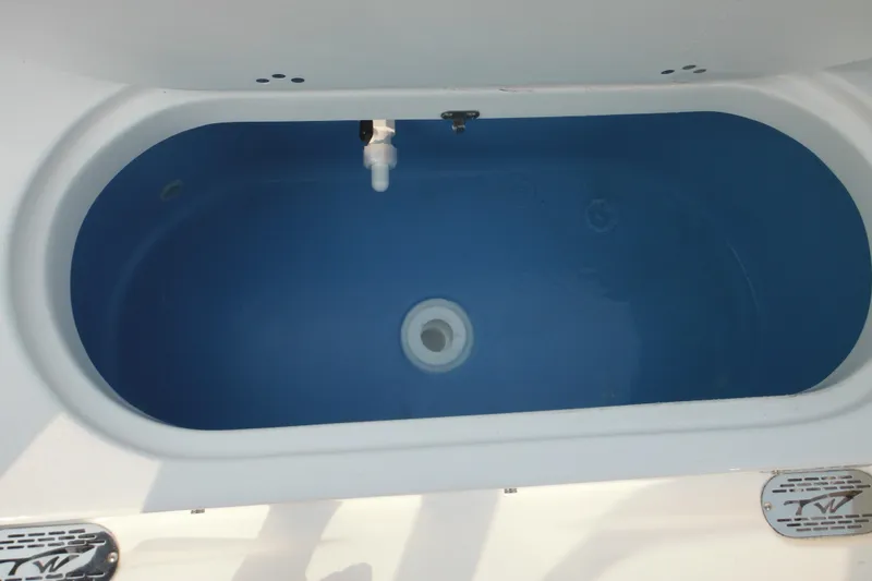 Slide: The Image of Livewell of 2026 Tidewater 232 LXF boat, featuring a blue interior. - 19