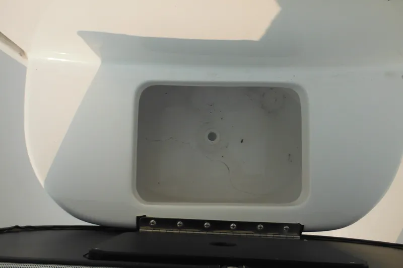 Slide: The Image of Open storage compartment on 2026 Tidewater 232 LXF boat, featuring a white interior. - 38