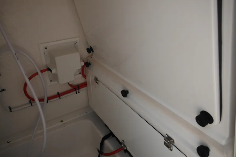 Slide: The Image of Interior view of 2026 Tidewater 232 LXF boat, showcasing storage compartments and wiring. - 72