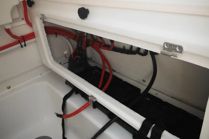 Slide: The Image of 2026 Tidewater 232 LXF boat wiring compartment with red and black cables. - 73