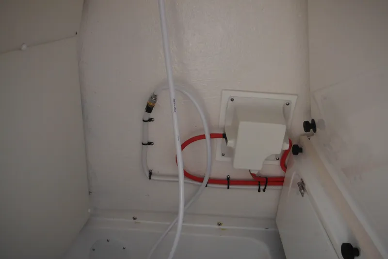 Slide: The Image of Interior view of 2026 Tidewater 232 LXF boat showing plumbing and wiring setup. - 75