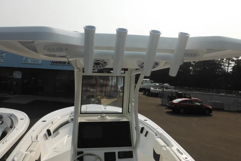 Slide: The Image of 2026 Tidewater 232 LXF boat with T-top and rod holders, parked outdoors. - 80