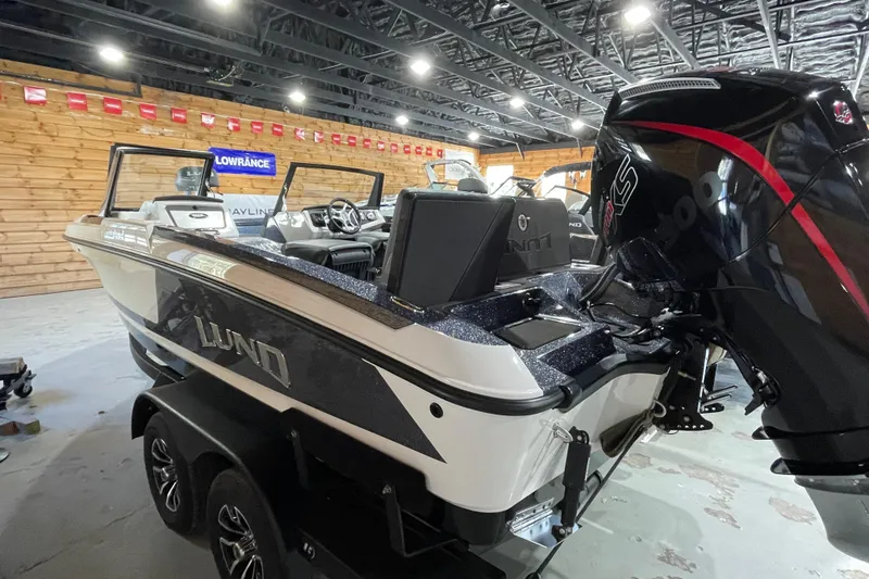 Slide: The Image of 2026 Lund 202 Pro-V GL boat in showroom, featuring sleek design and powerful engine. - 10