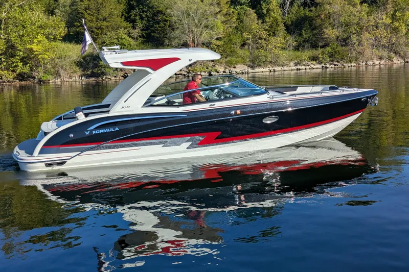 The Image of 2021 Formula 310 Bowrider I/O cruising on a serene lake with lush greenery. - 0
