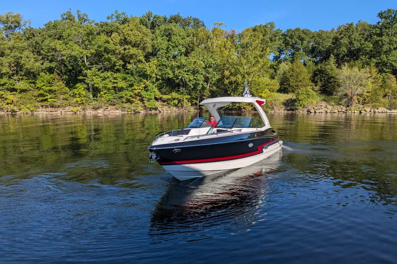 Slide: The Image of 2021 Formula 310 Bowrider I/O cruising on a serene lake with lush green trees. - 18