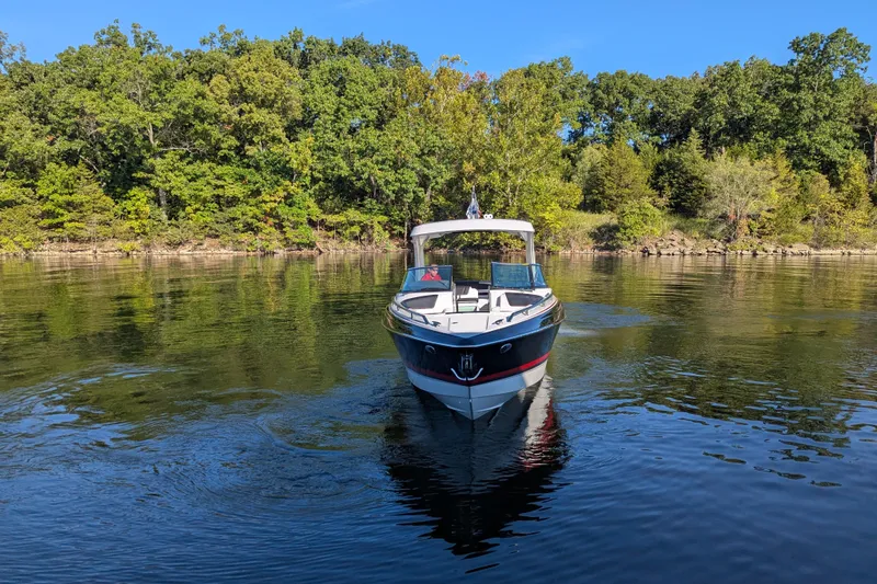 Slide: The Image of 2021 Formula 310 Bowrider I/O on calm lake with lush green forest backdrop. - 19
