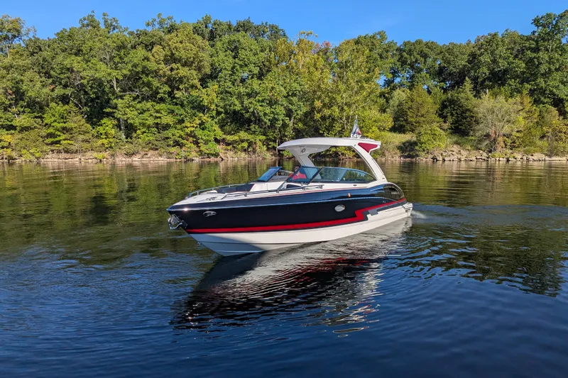 Slide: The Image of 2021 Formula 310 Bowrider I/O cruising on a serene lake with lush green trees. - 22