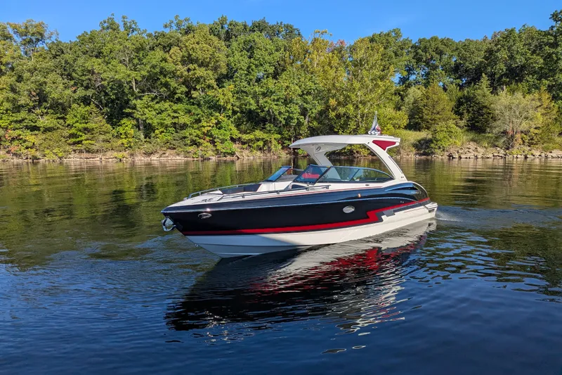 Slide: The Image of 2021 Formula 310 Bowrider I/O cruising on a serene lake with lush green trees. - 23