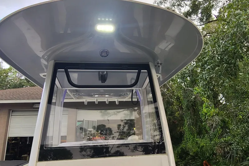 Slide: The Image of 2018 Sea Hunt Gamefish 25 boat with T-top and LED lights, surrounded by greenery. - 12