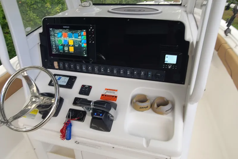 Slide: The Image of 2018 Sea Hunt Gamefish 25 dashboard with steering wheel, electronic controls, and navigation display. - 14