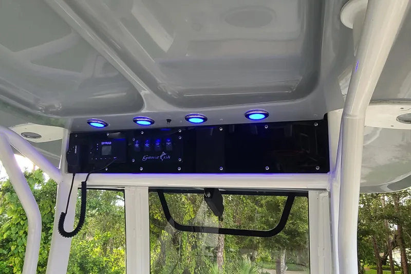 Slide: The Image of 2018 Sea Hunt Gamefish 25 boat console with blue LED lights and control panel. - 18