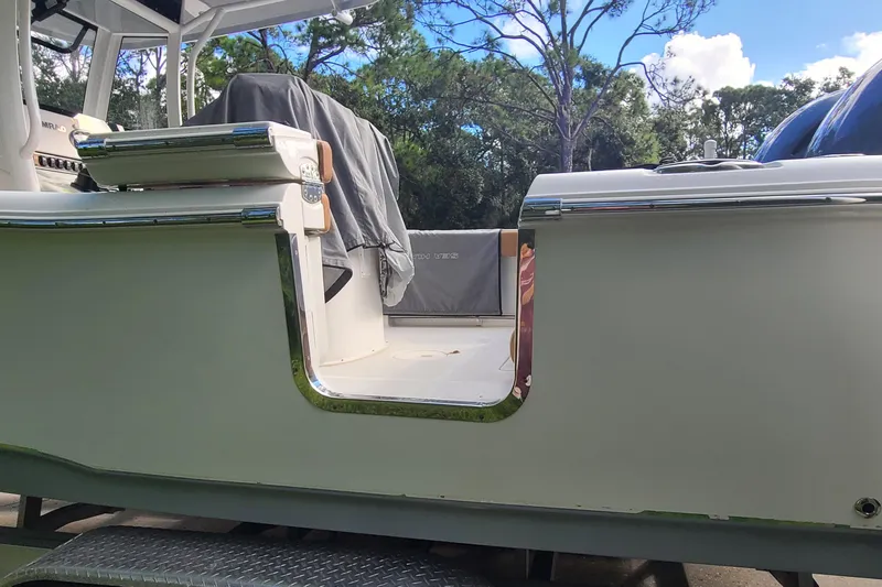 Slide: The Image of 2018 Sea Hunt Gamefish 25 boat with open side door, surrounded by trees. - 34