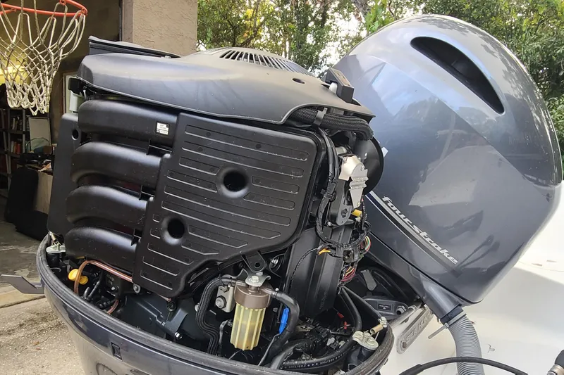 Slide: The Image of 2018 Sea Hunt Gamefish 25 outboard motor with open cover, showcasing engine components. - 37