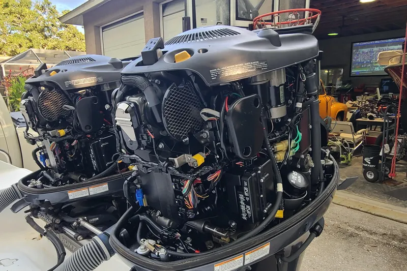 Slide: The Image of Twin outboard engines on a 2018 Sea Hunt Gamefish 25 boat in a garage setting. - 40