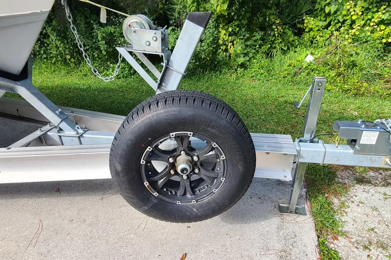 Slide: The Image of Trailer wheel of a 2018 Sea Hunt Gamefish 25 boat, parked on concrete. - 49