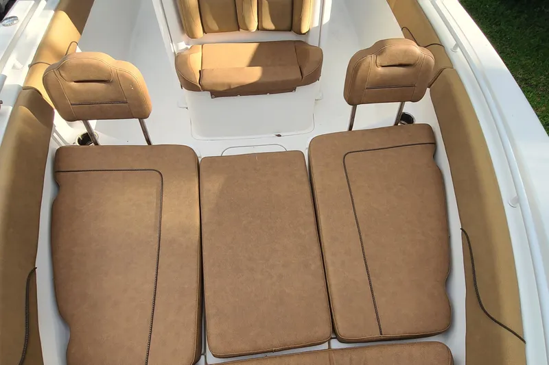 Slide: The Image of 2018 Sea Hunt Gamefish 25 boat interior with tan cushioned seating. - 9