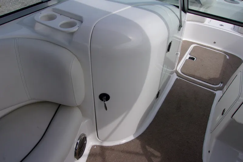 Slide: The Image of 2014 Hurricane Sundeck 217 IO interior with seating, cup holders, and carpeted flooring. - 10