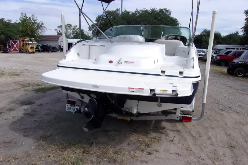 Slide: The Image of 2014 Hurricane Sundeck 217 IO boat, rear view, parked on a trailer in a yard. - 3