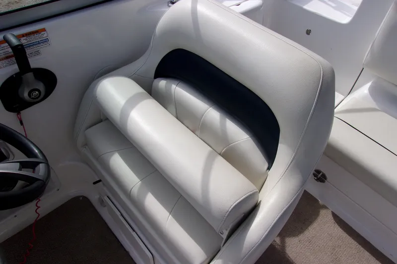 Slide: The Image of 2014 Hurricane Sundeck 217 IO boat seat with white upholstery and steering wheel. - 5