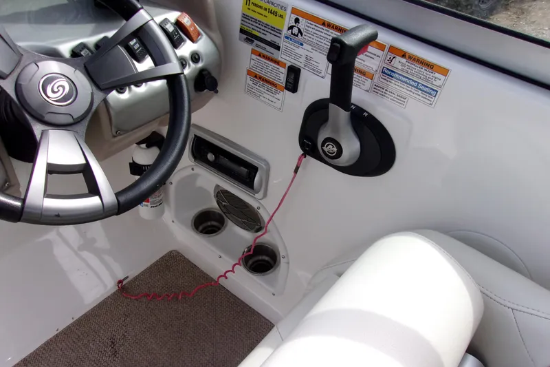 Slide: The Image of 2014 Hurricane Sundeck 217 IO boat cockpit with steering wheel and control panel. - 6