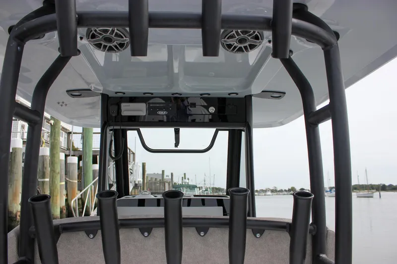 Slide: The Image of 2026 Sea Hunt Gamefish 28 boat interior with rod holders and speakers at a marina. - 28