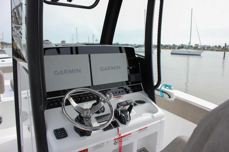Slide: The Image of 2026 Sea Hunt Gamefish 28 helm with dual Garmin displays, steering wheel, and controls. - 29