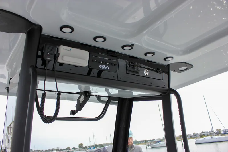 Slide: The Image of 2026 Sea Hunt Gamefish 28 console with Garmin electronics and overhead storage. - 45