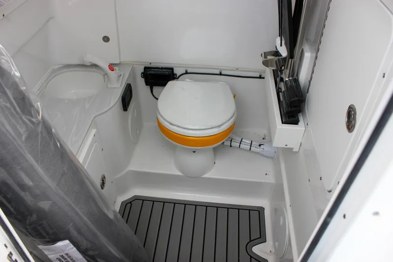 Slide: The Image of 2026 Sea Hunt Gamefish 28 boat interior with compact marine toilet and storage. - 55