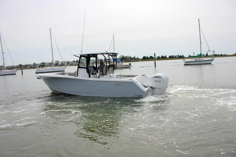 Slide: The Image of 2026 Sea Hunt Gamefish 28 Forward Seating boat cruising in a marina with sailboats. - 59