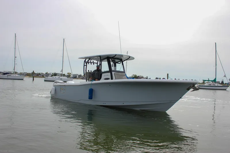 Slide: The Image of 2026 Sea Hunt Gamefish 28 Forward Seating boat on calm water, surrounded by sailboats. - 62