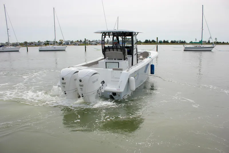 Slide: The Image of 2026 Sea Hunt Gamefish 28 Forward Seating boat with twin Yamaha engines on calm water. - 65