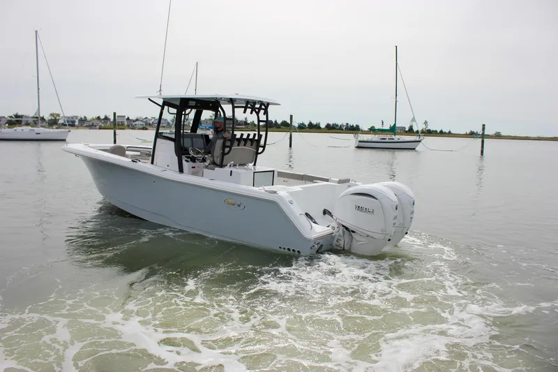 Slide: The Image of 2026 Sea Hunt Gamefish 28 Forward Seating boat on calm water, featuring dual engines. - 70