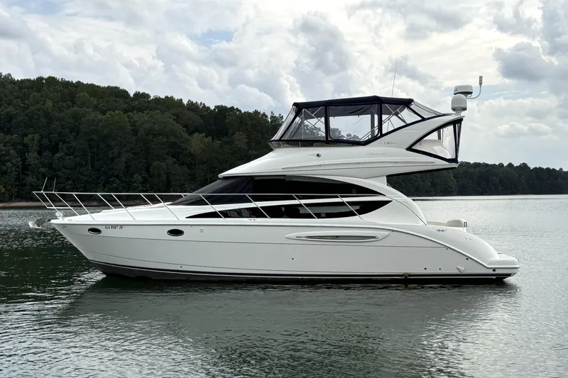 Slide: The Image of 2008 Meridian 391 yacht on calm water with forested shoreline in the background. - 0