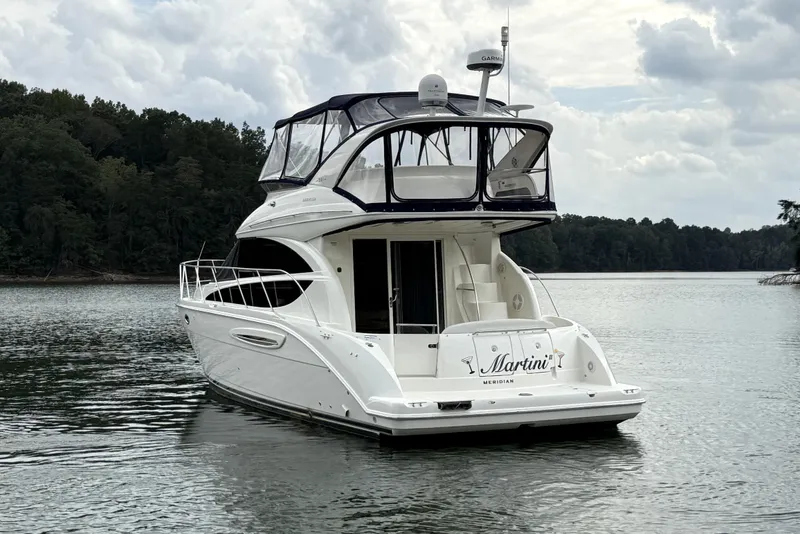 Slide: The Image of 2008 Meridian 391 yacht named "Martini" on a serene lake with forested background. - 1