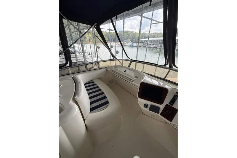 Slide: The Image of 2008 Meridian 391 yacht interior with striped seating and control panel, docked at marina. - 11